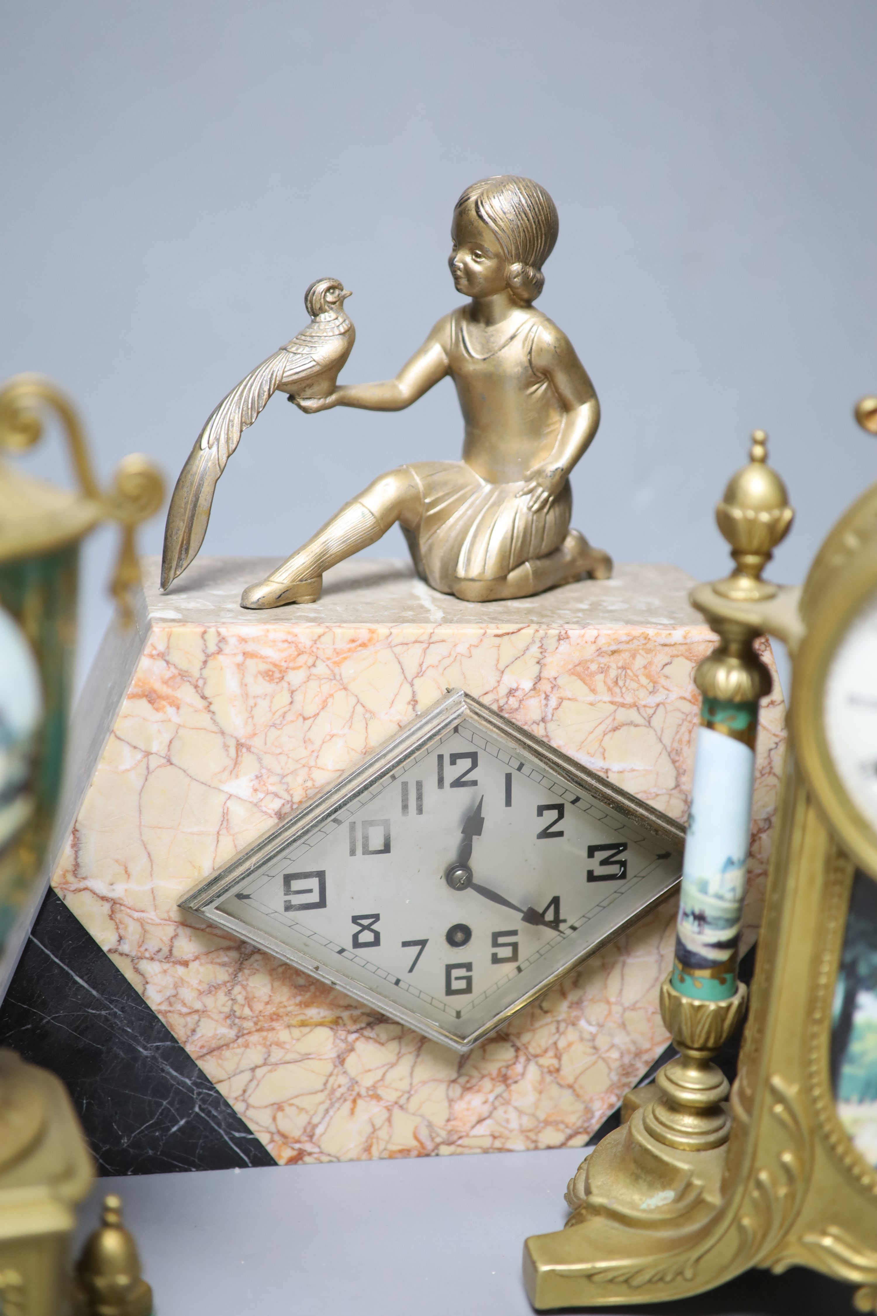 A Louis XV style gilt metal and porcelain three piece clock set and an Art Deco mantel clock, tallest 35cm